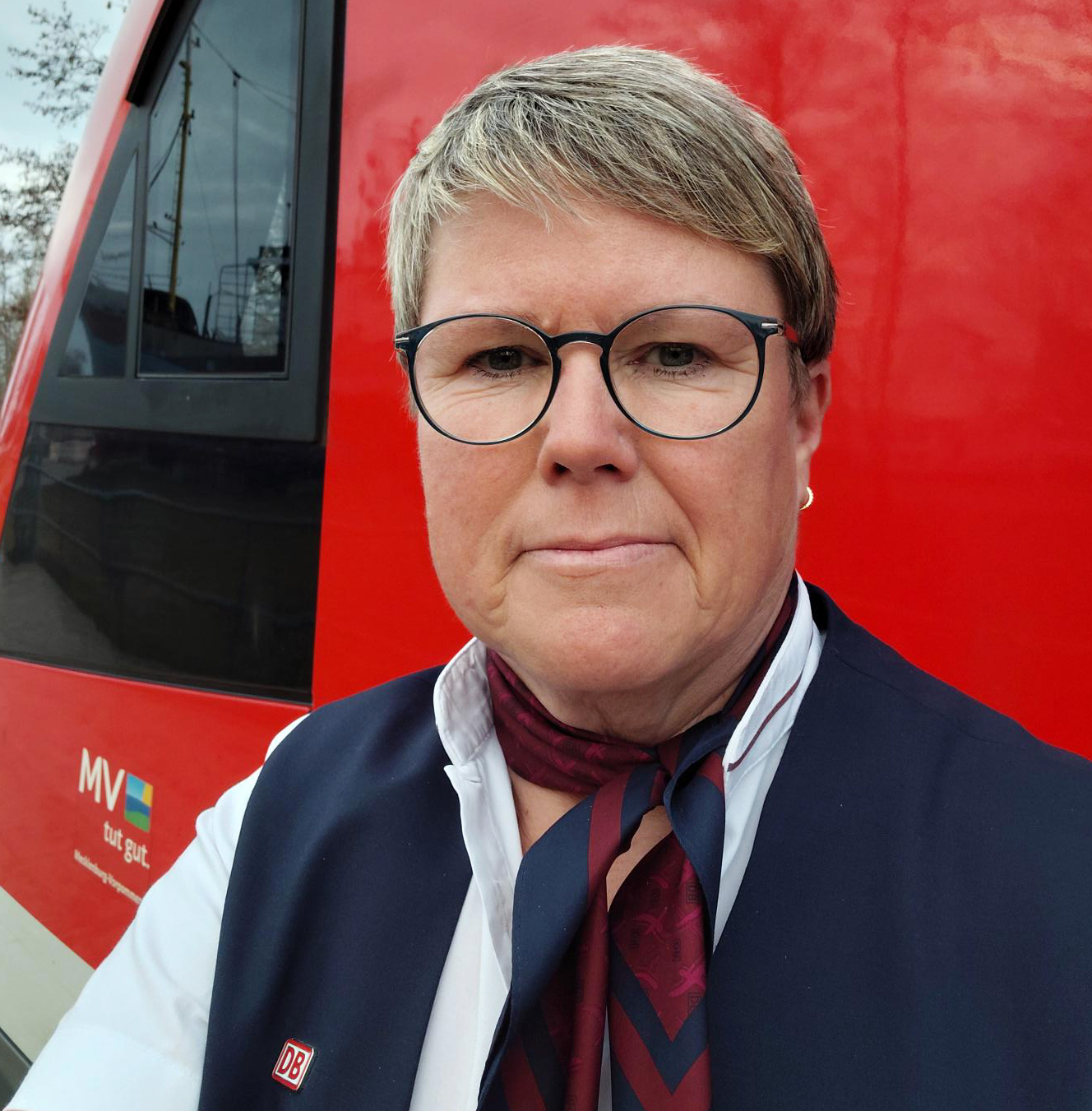 Portrait von Kundenbetreuerin Silke Schulz vor einem roten Regionalzug.